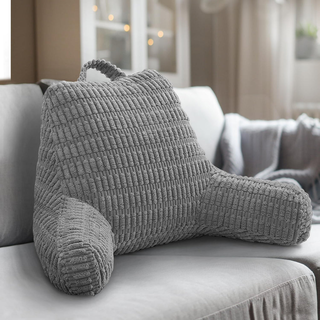 Gray textured backrest pillow on a sofa in a cozy living room.