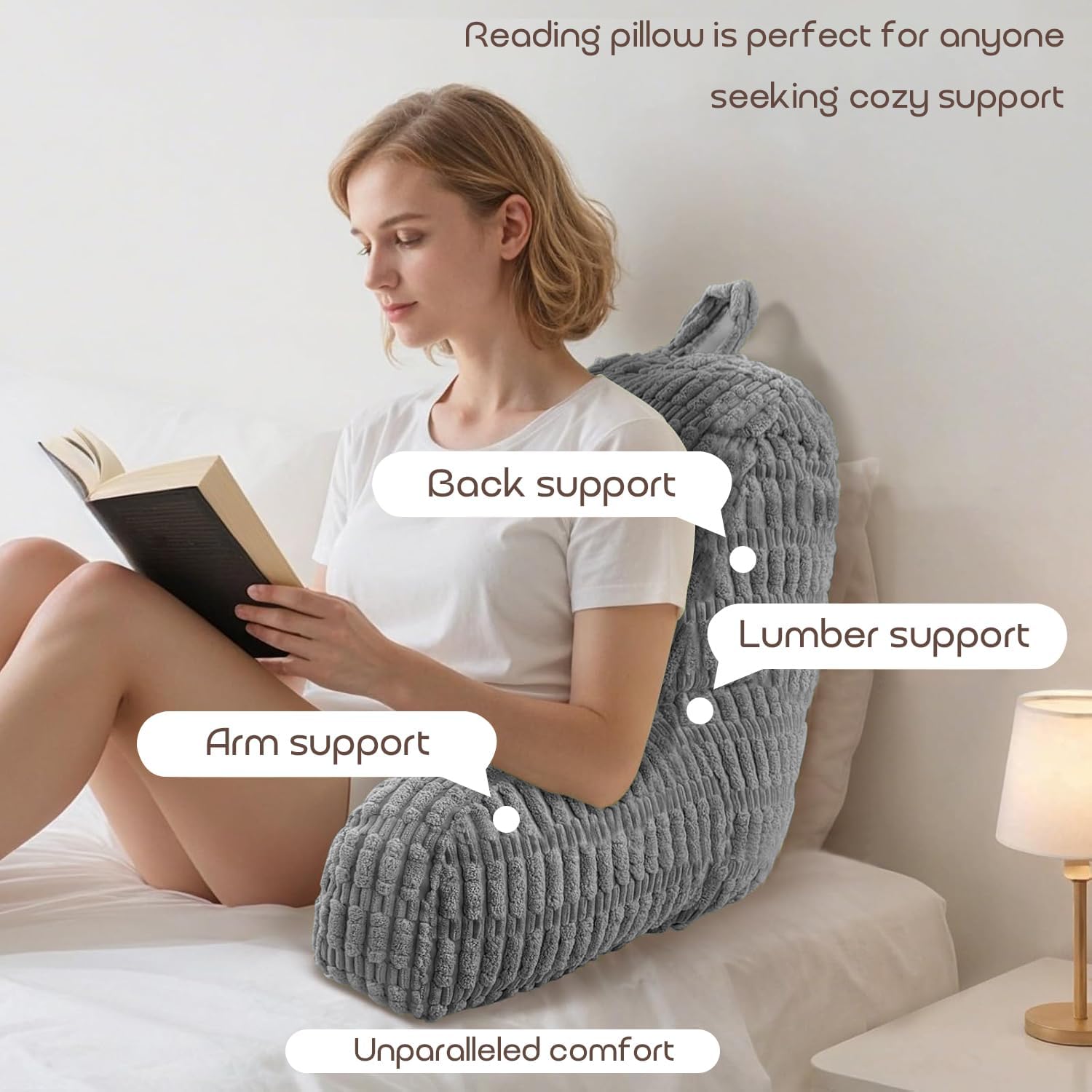 Woman reading a book with a gray reading pillow providing back, arm, and lumber support.