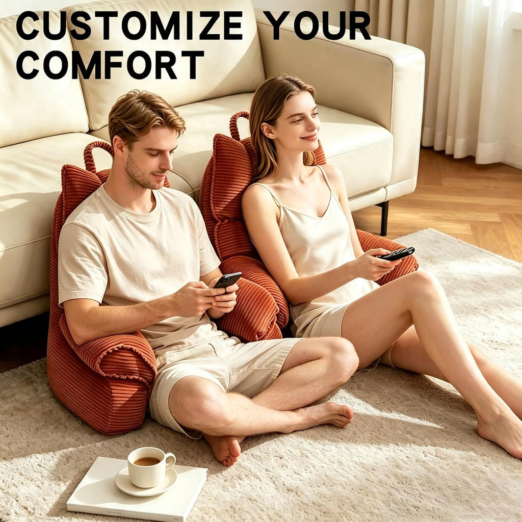 A man and a woman sit on a beige sofa in a living room, each leaning against a rust-red corduroy bean bag chair. Large text at the top reads 'CUSTOMIZE YOUR COMFORT'.